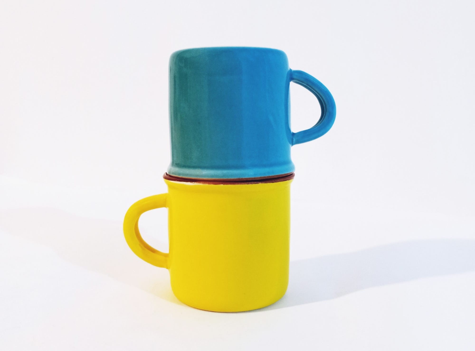 a yellow and blue cup sitting on top of each other